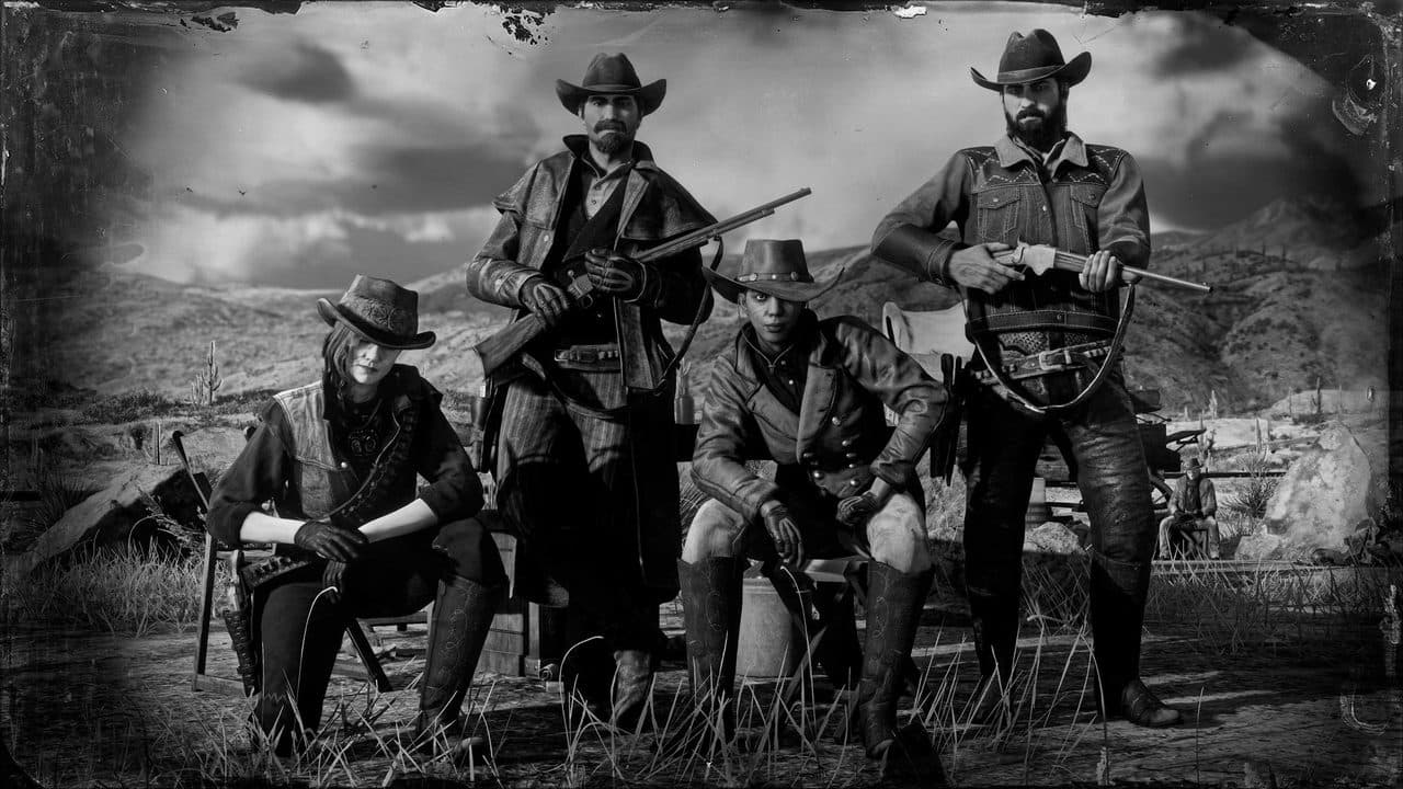 A posse of 4 pose together nearby rocky mountains